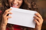 closeup-happy-young-woman-licking-envelope-womanin-kitchen-34452637